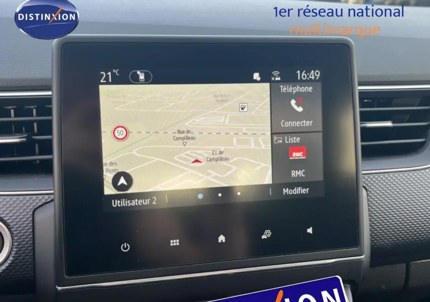 Vue rapprochée de l’écran tactile central du Renault Arkana gris Cassiopée Métal, affichant la navigation et les options connectées.