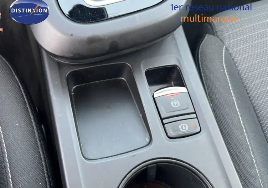 Gros plan sur la console centrale noire du Renault Arkana 2025, montrant les boutons de frein à main et auto hold.