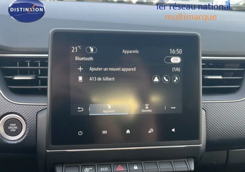 Écran tactile central du Renault Arkana gris Cassiopée métal, vue frontale du tableau de bord avec bouton start visible à gauche.