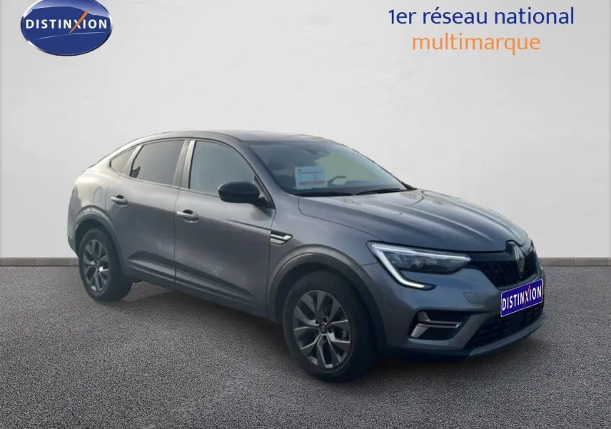 Renault Arkana gris Cassiopée métal en 3/4 avant droit, avec feux LED et calandre distinctive, modèle 2025 hybride essence.