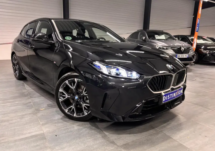 BMW Série 1 118d M Sport noir métal vue 3/4 avant avec calandre M Sport et jantes alliage 18 pouces bicolores.
