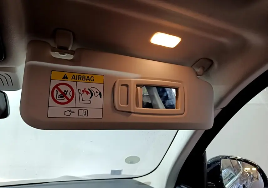 Détail du pare-soleil côté conducteur avec miroir éclairé dans un BMW X3 noir, vue intérieure avant.