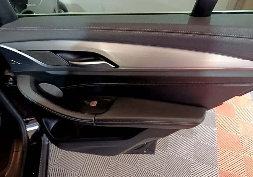 Gros plan sur la porte intérieure côté conducteur noire avec insert aluminium du BMW X3 sDrive18d 2019 Luxury.