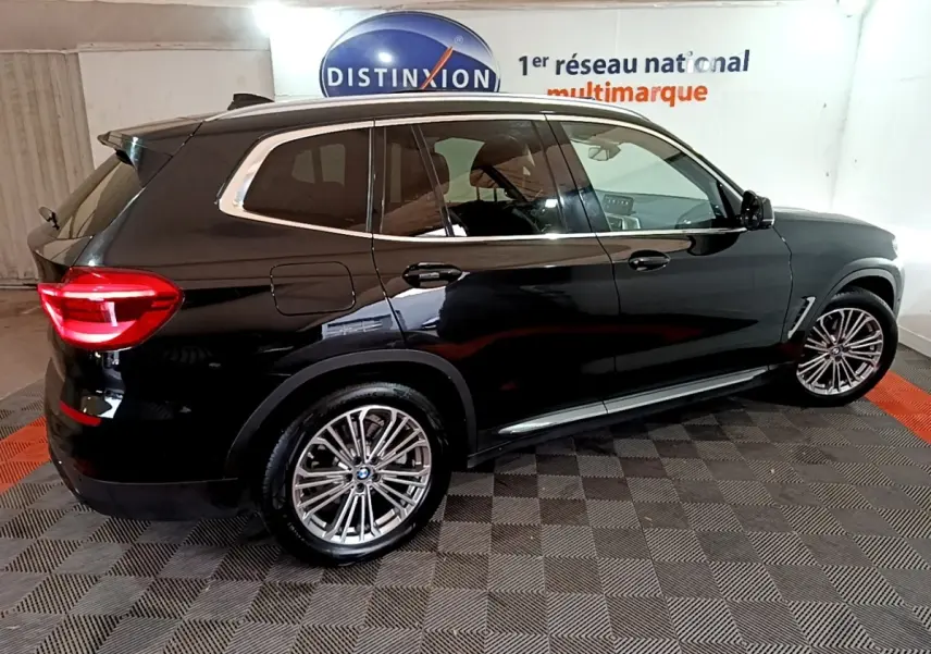 BMW X3 sDrive18d noir vue de profil droit en intérieur, soulignant ses jantes alliage et vitres teintées.
