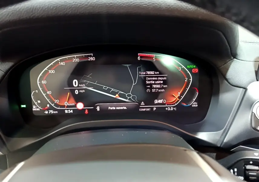 Vue rapprochée du tableau de bord numérique du BMW X3 noir, affichant la navigation et les indicateurs de vitesse.