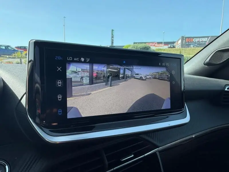 Écran tactile intérieur du Peugeot 2008 Hybrid 2025 affichant la caméra de recul avec vue arrière du véhicule.