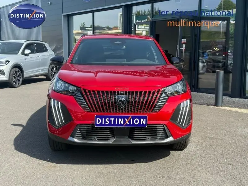 Vue frontale d'un Peugeot 2008 rouge Elixir 2025 avec calandre noire et feux LED verticaux distinctifs.