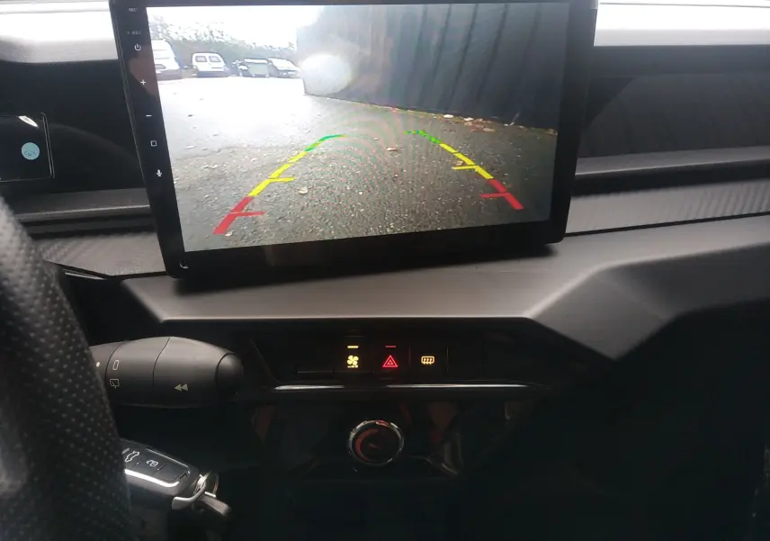 Vue intérieure centrée sur l'écran de caméra de recul du tableau de bord du Ligier JS50 blanc glacier 2026.