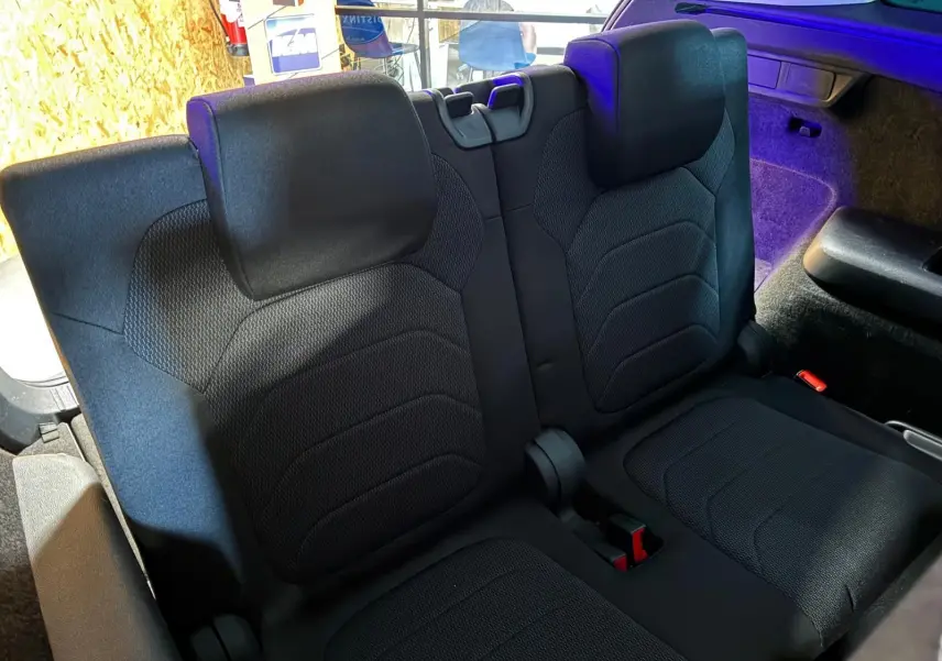 Vue rapprochée des sièges arrière en tissu noir du Skoda Kodiaq 2023, avec habillage intérieur et coffre partiellement visible.