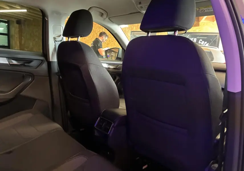Vue intérieure arrière du Skoda Kodiaq 2023, sièges tissu noir et console centrale avec aérateurs arrière visibles.