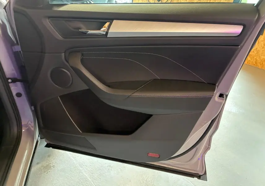 Vue rapprochée de la porte arrière gauche gris clair du Skoda Kodiaq 2023, avec garniture noire et insert décoratif clair.