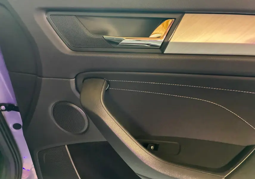 Détail de la porte intérieure côté gauche du Skoda Kodiaq 2023, avec garniture noire et insert décoratif clair.