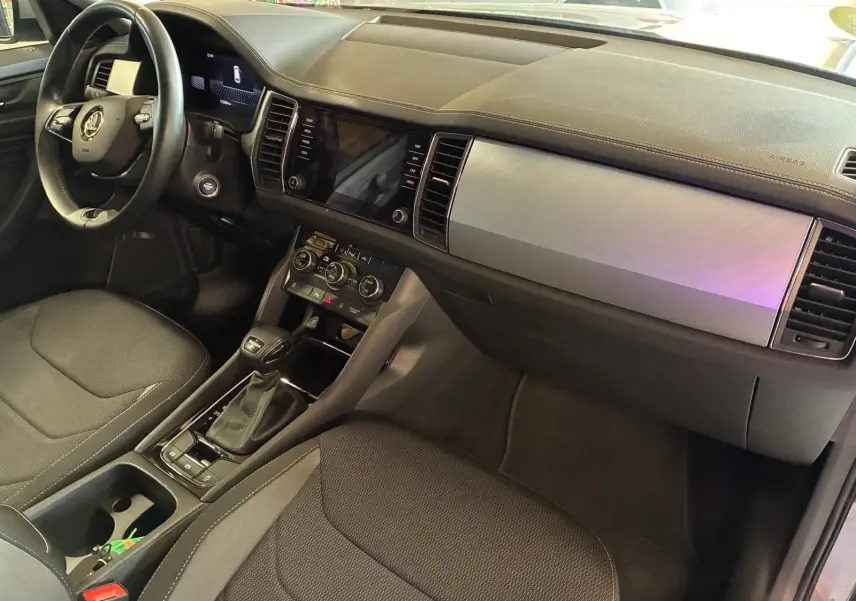 Intérieur noir du Skoda Kodiaq 2023, vue côté conducteur, tableau de bord moderne avec écran tactile et console centrale.