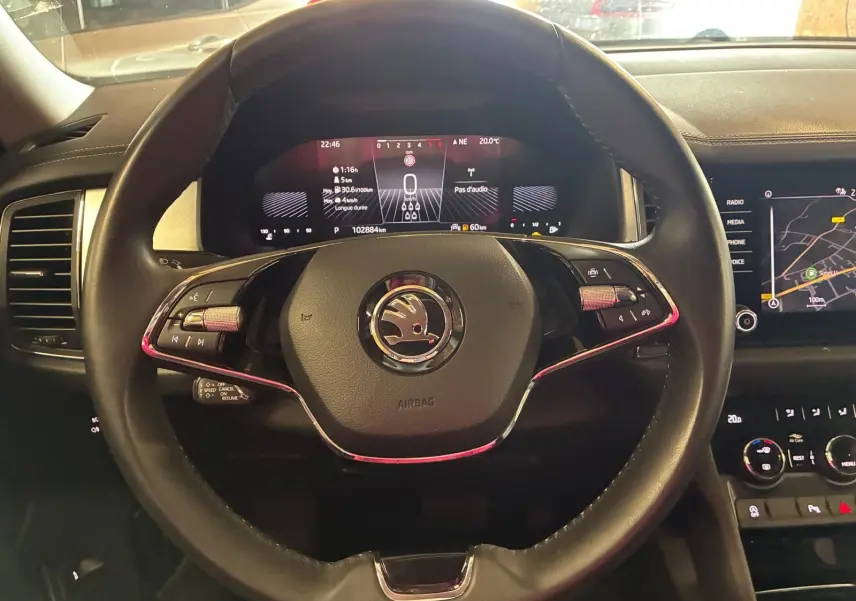 Vue rapprochée du volant noir du Skoda Kodiaq 2023 avec tableau de bord digital et écran central tactile allumé.