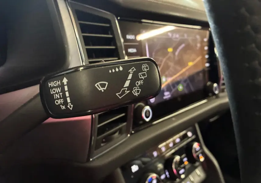Gros plan sur la commande d’essuie-glace du Skoda Kodiaq gris clair 2023, avec tableau de bord et écran tactile en arrière-plan.