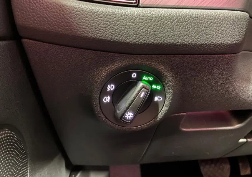 Gros plan sur le bouton de commande des phares du Skoda Kodiaq gris clair, éclairage automatique activé.