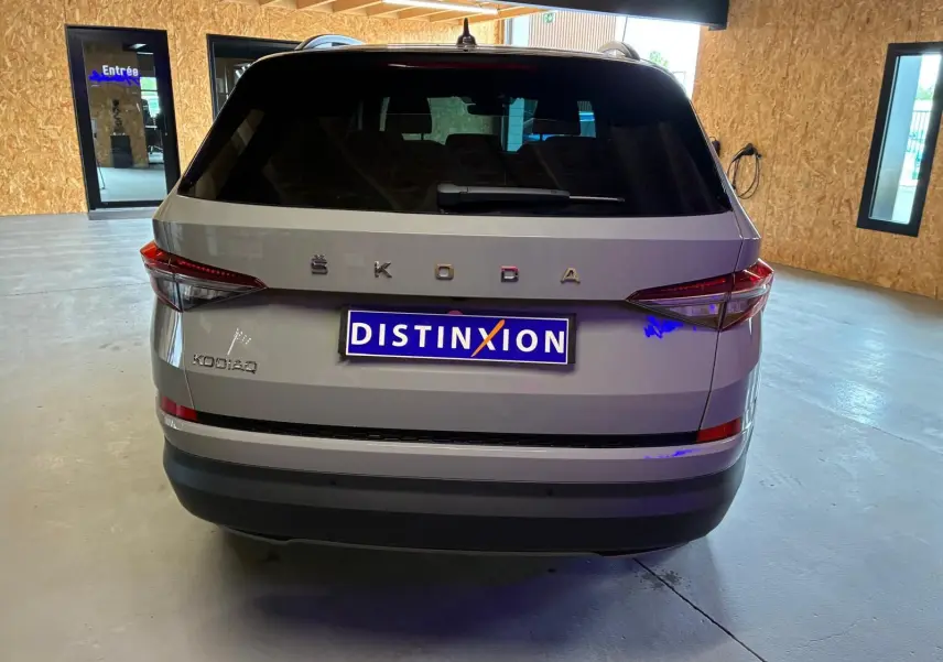 Vue arrière d'un Skoda Kodiaq gris clair 2023 avec feux arrière LED et plaque Distinxion dans un garage.