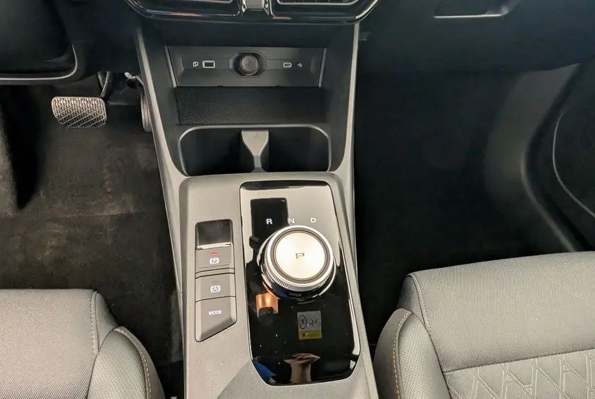 Vue rapprochée de la console centrale noire de la MG3 1.5 L Hybrid+ 2026 avec molette de boîte automatique et sièges gris.