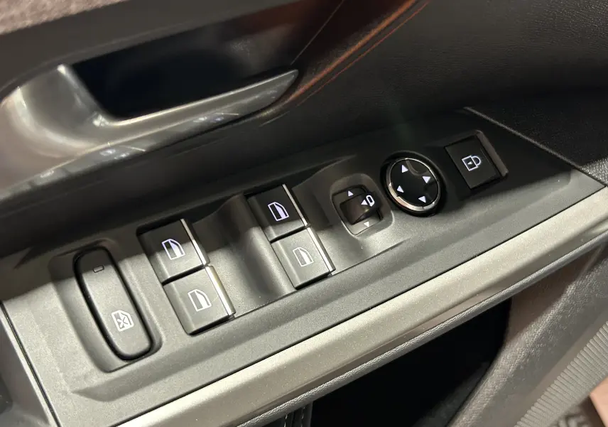 Gros plan sur les commandes de lève-vitres et rétroviseurs côté conducteur d’un Peugeot 3008, intérieur noir.