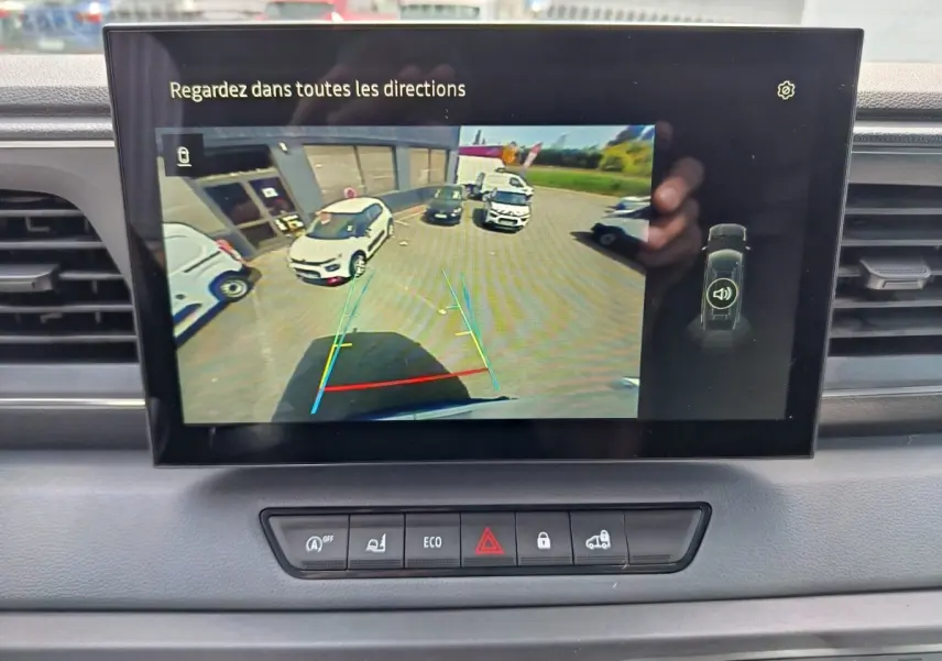 Écran tactile du tableau de bord du Renault Master 2025 montrant la caméra de recul avec vue arrière du véhicule blanc.
