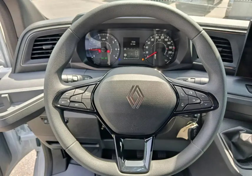 Vue rapprochée du volant noir du Renault Master 2025 avec commandes intégrées et tableau de bord numérique.