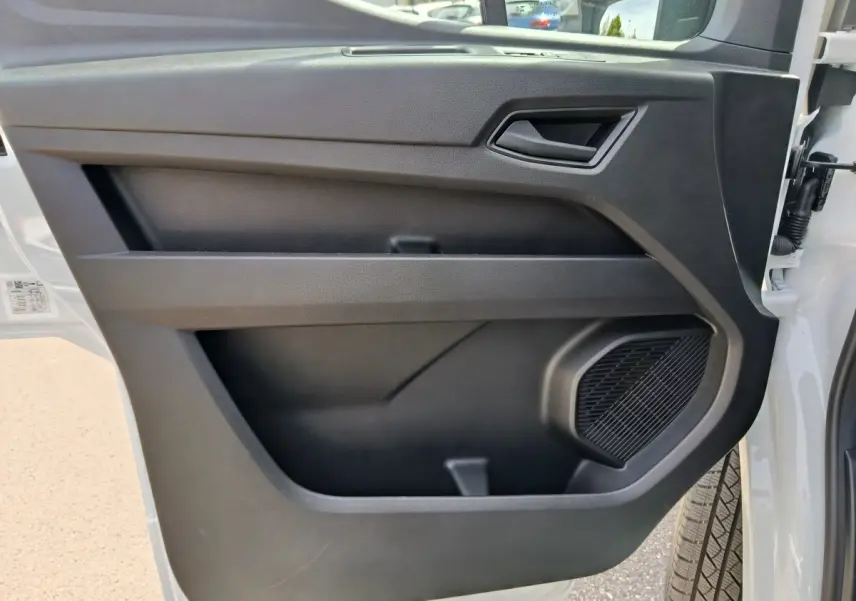 Vue rapprochée de la porte avant droite du Renault Master blanc 2025, avec haut-parleur intégré et poignée noire.