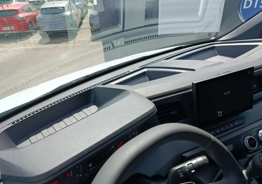 Vue intérieure du tableau de bord et volant noir du Renault Master blanc, avec écran tactile central et commandes visibles.