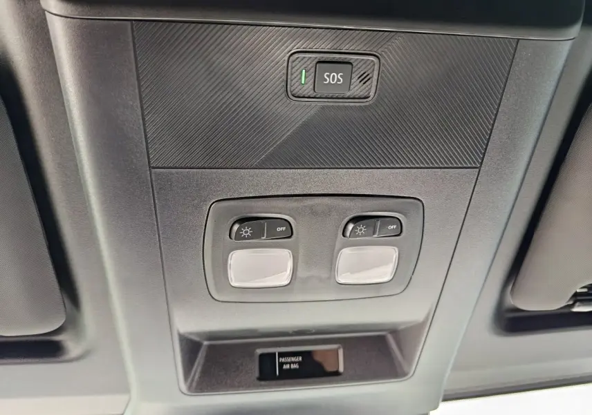 Vue en contre-plongée du plafonnier intérieur gris avec boutons d’éclairage et bouton SOS du Renault Master blanc 2025.