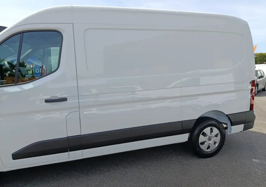 Vue latérale droite du Renault Master blanc, fourgon utilitaire avec jantes acier et protections noires sur les bas de caisse.