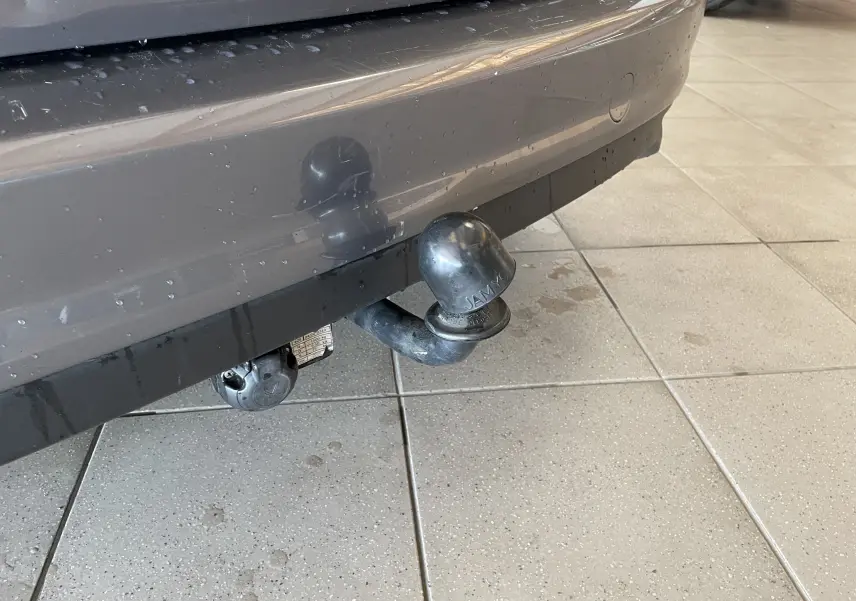 Gros plan sur l'attelage de remorque noir fixé au pare-chocs arrière gris d'une Ford C-MAX diesel de 2012.