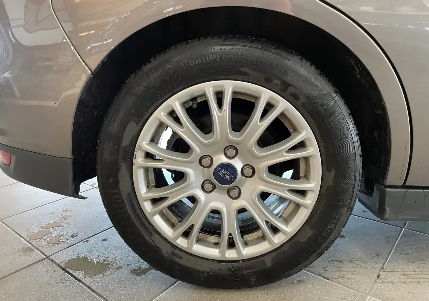 Gros plan sur la roue arrière droite grise d'une Ford C-MAX 2012 avec jante alliage et pneu Continental.