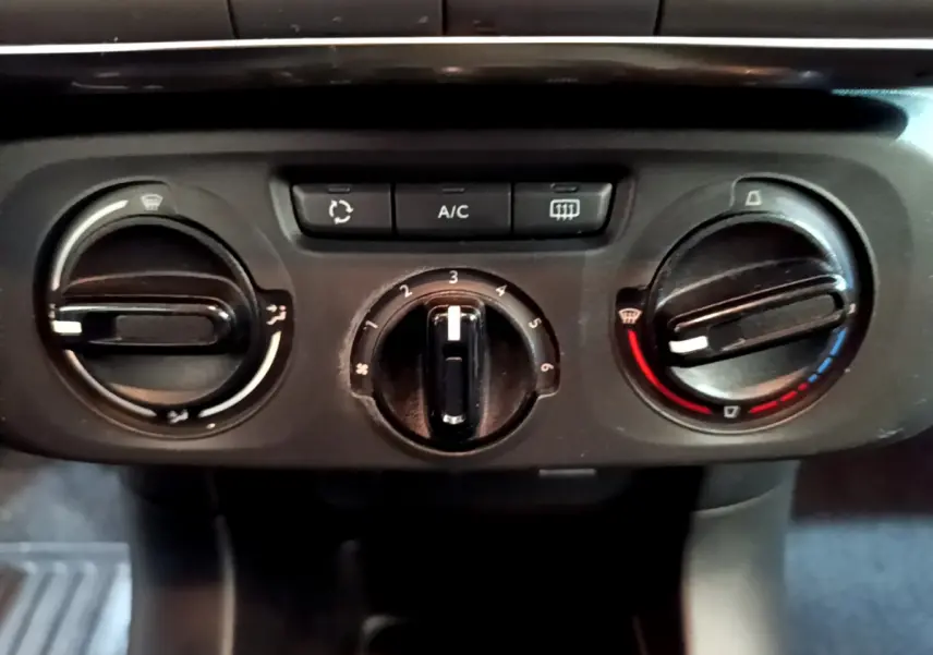 Commandes de climatisation manuelle de la Citroën C3 PureTech 68 BVM Feel 2018 en vue rapprochée, boutons noirs sur tableau de bord.