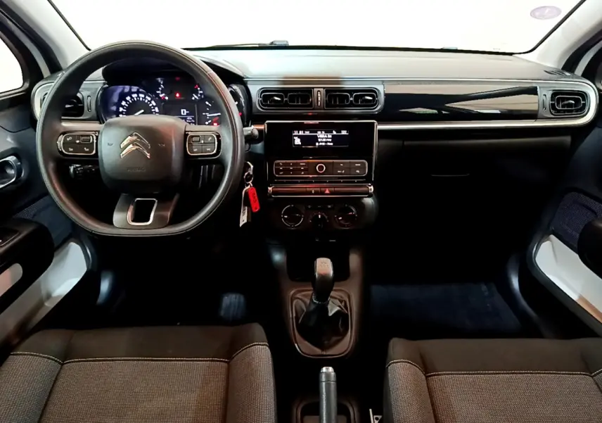 Tableau de bord et intérieur noir de la Citroën C3 PureTech 68 BVM Feel 2018 vus de face, volant multifonctions et levier manuel.