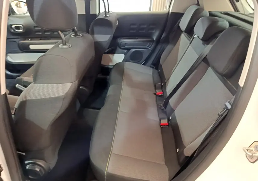 Vue intérieure côté droit de la banquette arrière grise et noire de la Citroën C3 blanche 2018 PureTech Feel.