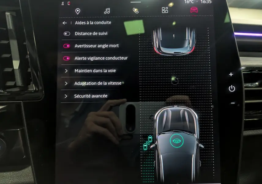 Écran tactile intérieur du Renault Austral E-Tech Hybrid 2024 montrant les aides à la conduite et la vue du véhicule en plan supérieur.