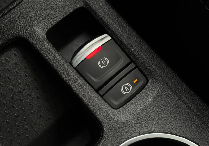 Gros plan sur la commande du frein de parking électrique et fonction Auto-Hold dans le console centrale noire du Renault Captur 2025.