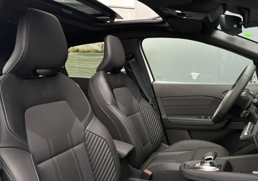 Vue intérieure côté droit du Renault Captur Esprit Alpine 2025, sièges noirs avec logo Alpine et toit ouvrant visible