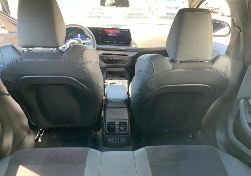 Vue arrière de l'intérieur noir Alcantara d'une BMW Série 1 118D 2025 avec console centrale et écran tactile.