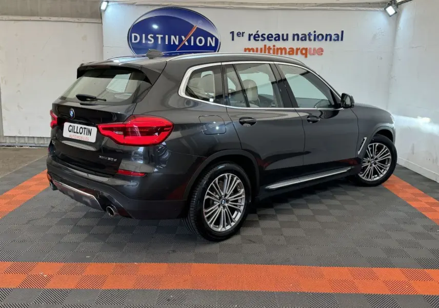BMW X3 xDrive30d gris foncé vu en 3/4 arrière droit, avec jantes alliage et feux arrière LED visibles.
