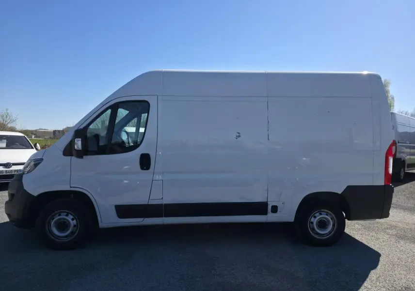 Fiat Ducato Fourgon blanc en vue de profil côté gauche, fourgon tôlé avec porte latérale coulissante.