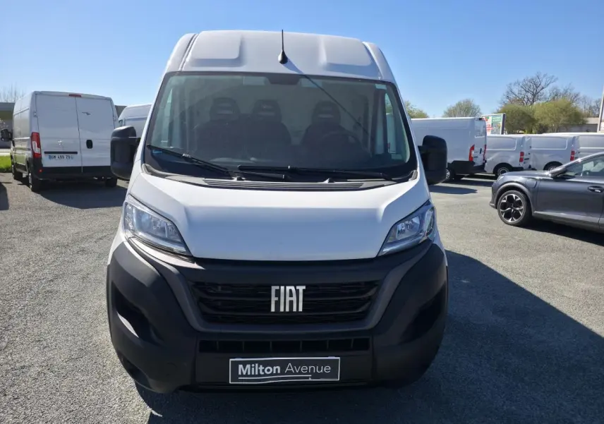 Vue de face d'un fourgon FIAT Ducato blanc avec calandre noire et plaque Milton Avenue, stationné en extérieur.