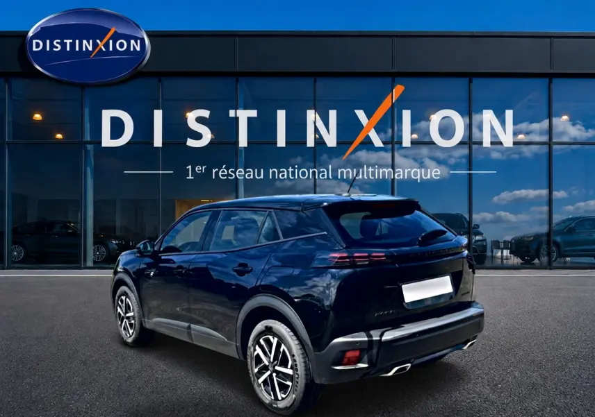 Peugeot 2008 noir en 3/4 arrière droit, avec becquet et feux arrière LED, devant une vitrine Distinxion.