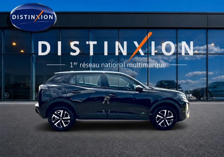 Profil côté gauche d’un Peugeot 2008 noir 2025 avec jantes alliage et vitres teintées devant un bâtiment vitré Distinxion.