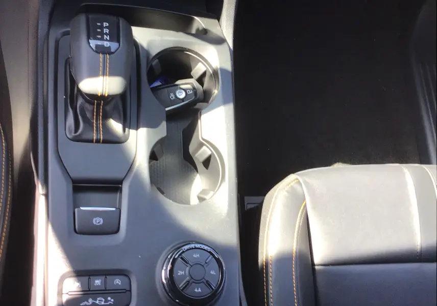 Vue plongeante sur la console centrale noire du Ford Ranger Wildtrak 2025 avec levier de vitesses et sellerie cuir gris carbone.