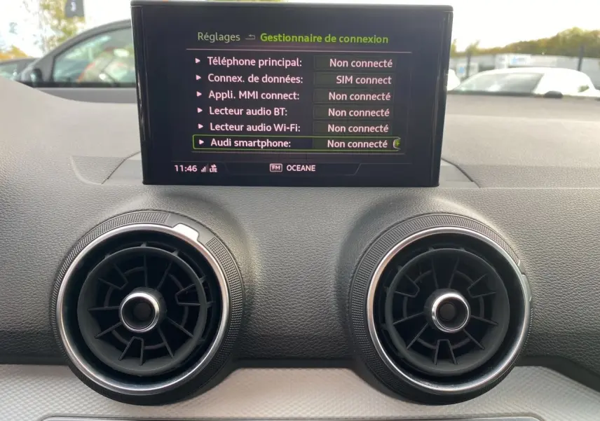 Détail du tableau de bord noir de l'Audi Q2 30 TDI 2019 avec écran central affichant le gestionnaire de connexion.