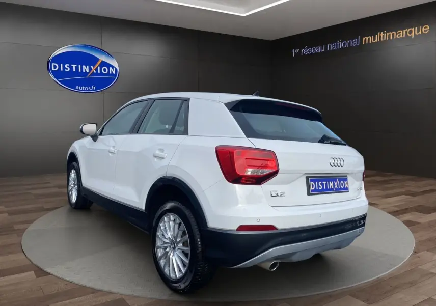 Audi Q2 blanc vue 3/4 arrière droit, mettant en valeur ses feux arrière et jantes alliage argentées.