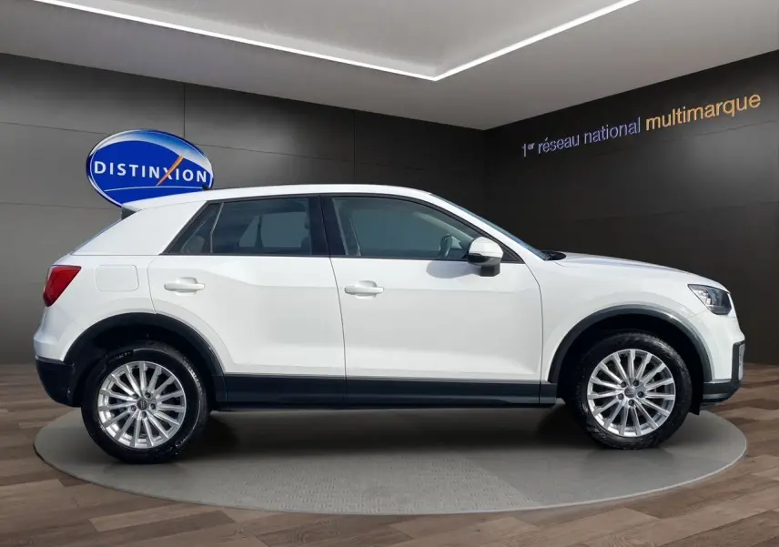 Profil côté gauche d'un Audi Q2 blanc 2019 avec jantes alliage et détails noirs sur les bas de caisse.