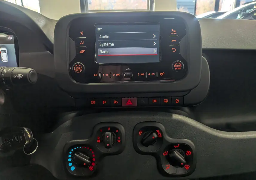Vue rapprochée du tableau de bord de la Fiat Panda 2025 Bleu Italia, avec écran tactile et commandes climatiques visibles.