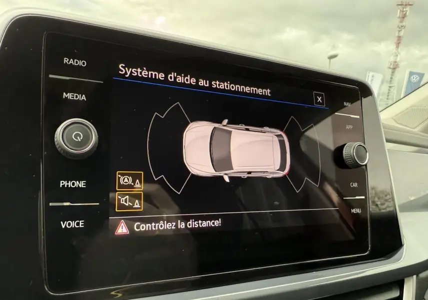 Écran tactile du système d'aide au stationnement du Volkswagen T-Roc rouge Kings Red, vue intérieure centrale.