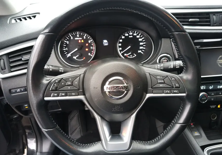 Vue rapprochée du volant cuir noir du Nissan Qashqai 2019, avec commandes intégrées et tableau de bord visible.